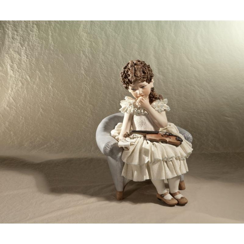 lalka z porcelany siedzaca dziewczynka